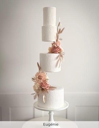 White floating tier cake with blush silk flowers and lace pattern