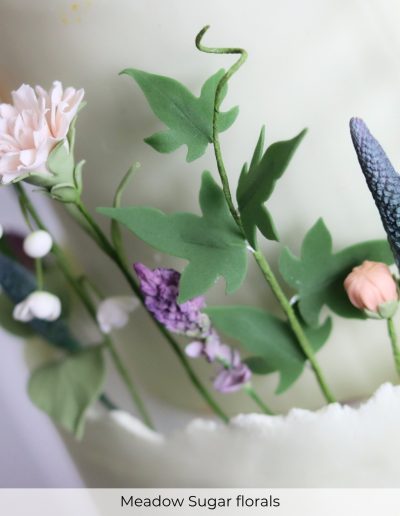 Wild meadow-inspired sugar flowers in soft pastels on wedding cake