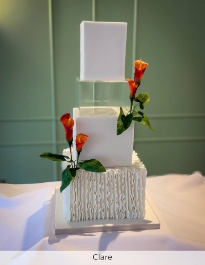 Contemporary square autumnal wedding cake with orange calla lilies and ruffle base