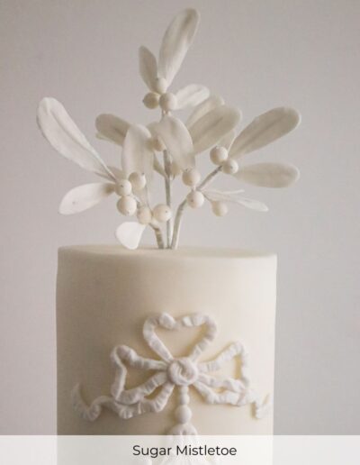 Handcrafted sugar mistletoe topper on a luxury bespoke wedding cake created for a winter wedding at Buxton Crescent Hotel