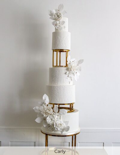 Luxury bespoke multi-tier wedding cake with handcrafted sugar flowers and gold spacers, created for a large cultural wedding at Ye Olde Bell near Doncaster