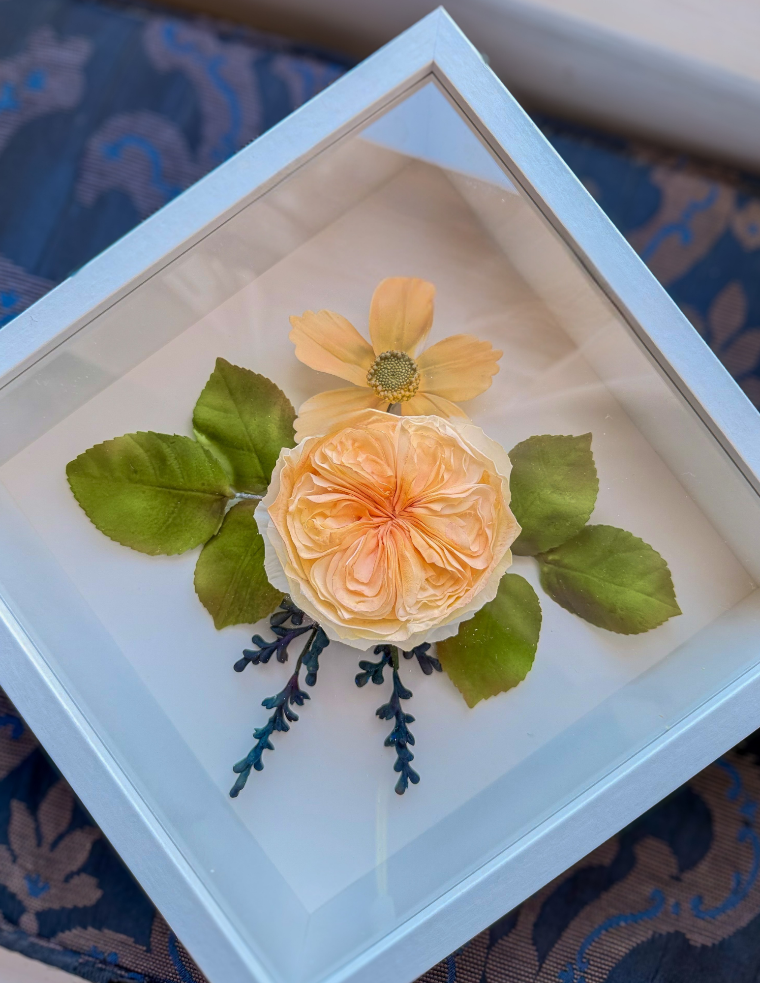 Handcrafted sugar rose and foliage preserved in a wedding cake keepsake shadow box.